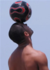 balancing a soccer ball on his head